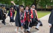 Graduating students walk across the University Seal